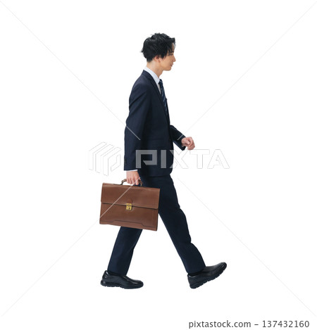 A male business person walking in a suit. A transparent, hand-cut, full-body PNG photo. 137432160