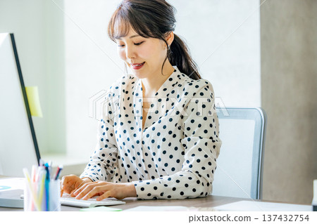 A young lady who operates a personal computer A young lady who operates a personal computer 137432754