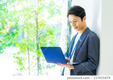 A businessman with a laptop computer A businessman with a laptop computer 137433874