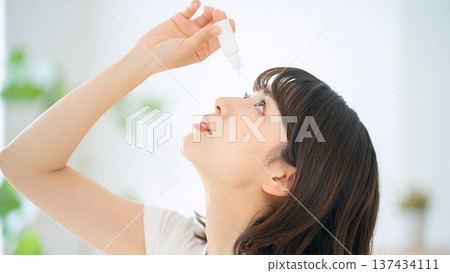 一位日本女性使用眼藥水來緩解眼睛乾澀和花粉症。 137434111