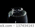 Splashes of water and a transparent water crown in the darkness 137434143