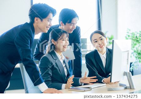 辦公室裡，新來的男女員工正對著電腦開會。 137434275