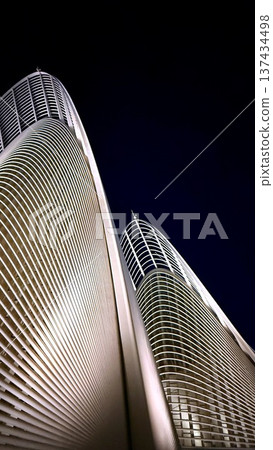 Reflective Curvature Meets Dramatic Lighting With Sweeping Ribs And Curved Fins Against Deep Blue Sky, Strong Vertical Emphasis And Pristine Surfaces For Editorial Use Reflective Curvature Meets Dramatic Lighting With Sweeping Ribs And Curved Fins Against Deep Blue Sky, Strong Vertical Emphasis And Pristine Surfaces For Editorial Use 137434498