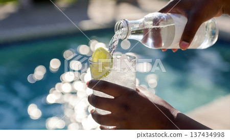 Pouring Sparkling Water With Lime by Pool Pouring Sparkling Water With Lime by Pool 137434998