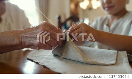 Grandparent and Child Folding Linen Napkin Together Grandparent and Child Folding Linen Napkin Together 137435034