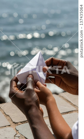 Adult and Child Folding Paper Boat by Water 137435064