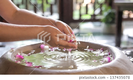 Hands Releasing Flower Petals Into Spa Water Bowl Hands Releasing Flower Petals Into Spa Water Bowl 137435078