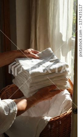 Older Hands Placing Folded Linens In Basket Older Hands Placing Folded Linens In Basket 137435117