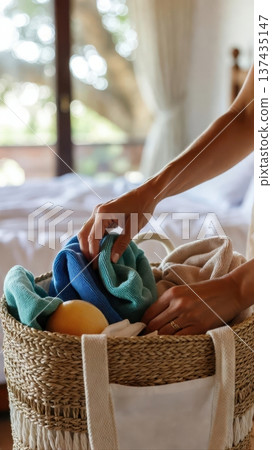 Packing towels and toiletries in woven basket at home Packing towels and toiletries in woven basket at home 137435147