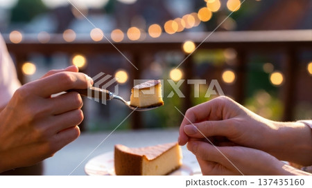 Sharing cheesecake bite on rooftop at sunset Sharing cheesecake bite on rooftop at sunset 137435160