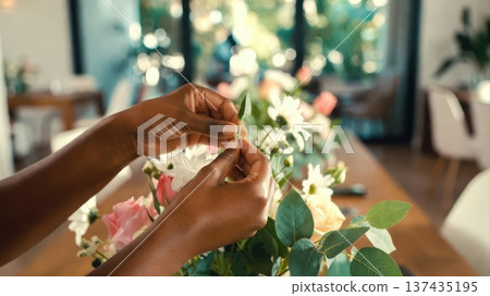 Adjusting greenery in flower arrangement on dining table Adjusting greenery in flower arrangement on dining table 137435195