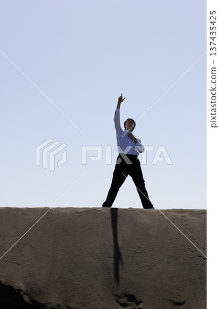Silhouette of a man raising his right hand Silhouette of a man raising his right hand 137435425