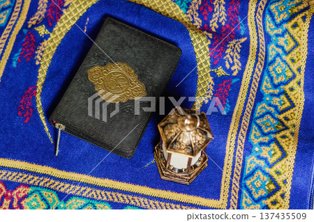 Holy Quran Book and Traditional Ramadan Lantern on Blue Prayer Rug Flat Lay. Islamic Holiday Greeting for Ramadan Kareem and Eid Mubarak. High quality photo Holy Quran Book and Traditional Ramadan Lantern on Blue Prayer Rug Flat Lay. Islamic Holiday Greeting for Ramadan Kareem and Eid Mubarak. High quality photo 137435509