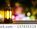 Glowing Traditional Arabic Lantern on Wooden Table with Colorful City Bokeh Background. Islamic Holiday Greeting for Ramadan Kareem and Eid Mubarak. High quality photo Glowing Traditional Arabic Lantern on Wooden Table with Colorful City Bokeh Background. Islamic Holiday Greeting for Ramadan Kareem and Eid Mubarak. High quality photo 137435519