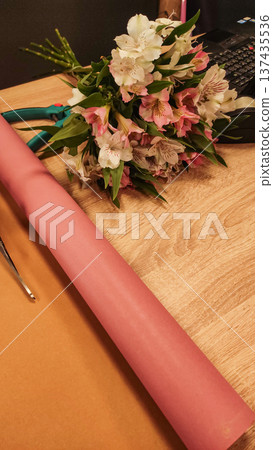 Florist arranging pink and white alstroemeria bouquet on wooden table in prague in flower shop 137435536