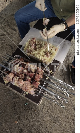 Cook preparing skewers of meat shashlik and onions for grilling in prague summer day 137435543