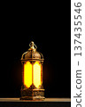 Vintage Ornate Lantern with Warm Glowing Light on Dark Background. Islamic Holiday Greeting for Ramadan Kareem and Eid Mubarak. High quality photo Vintage Ornate Lantern with Warm Glowing Light on Dark Background. Islamic Holiday Greeting for Ramadan Kareem and Eid Mubarak. High quality photo 137435546