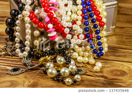 Jewelry box full of jewelry and accessories on wooden background Jewelry box full of jewelry and accessories on wooden background 137435646