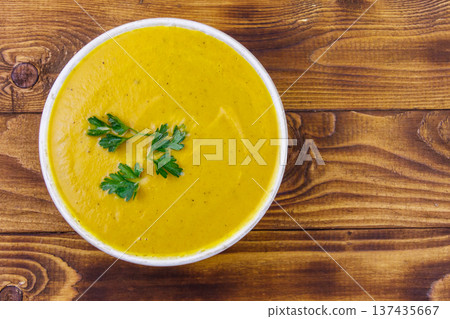Pumpkin soup on a wooden table. Top view Pumpkin soup on a wooden table. Top view 137435667