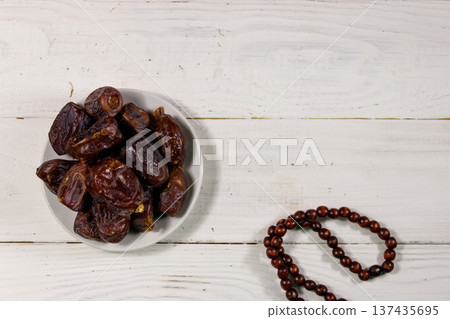 Dates fruit and rosary on white wooden table. Top view Dates fruit and rosary on white wooden table. Top view 137435695