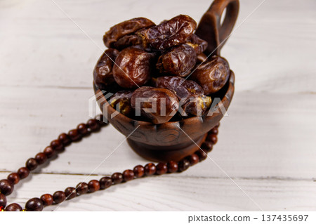 Dates fruit and rosary on white wooden table Dates fruit and rosary on white wooden table 137435697