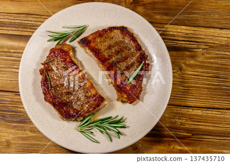 Grilled pork steaks with rosemary on wooden table. Top view Grilled pork steaks with rosemary on wooden table. Top view 137435710