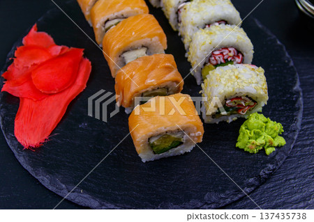 Set of sushi rolls on a black stone slate 137435738