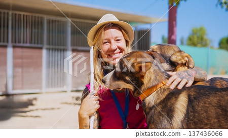 Woman volunteering at animal shelter hugging dogs Woman volunteering at animal shelter hugging dogs 137436066