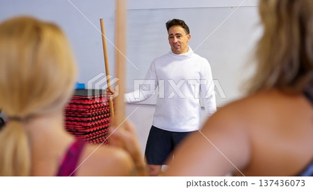 Instructor demonstrating exercises during class for women 137436073