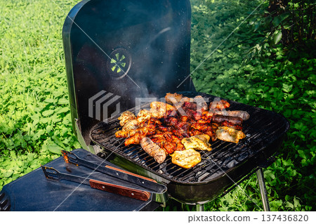grilled meat over the coals on barbecue 137436820