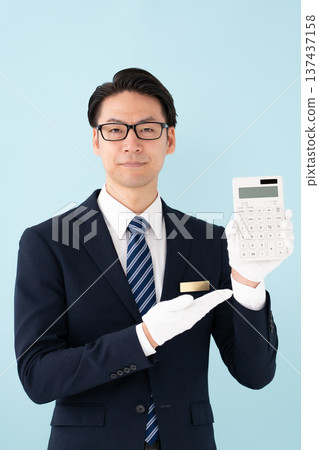 Man wearing white gloves holding a calculator Man wearing white gloves holding a calculator 137437158