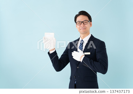 A man wearing white gloves holding a calculator A man wearing white gloves holding a calculator 137437173