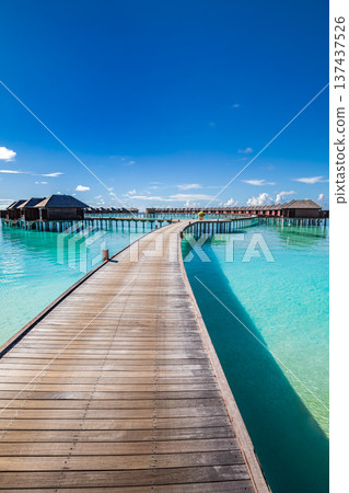 Maldives wooden pier leading to overwater villas turquoise ocean summer tourism luxury honeymoon tropical paradise vacation travel destination 137437526