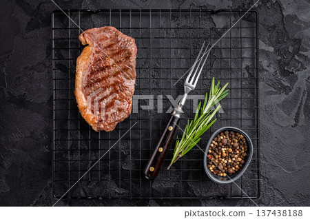 Juicy grilled striploin New York steak with perfect grill marks, ideal for a hearty meal or summer barbecue. black background. top view Juicy grilled striploin New York steak with perfect grill marks, ideal for a hearty meal or summer barbecue. black background. top view 137438188