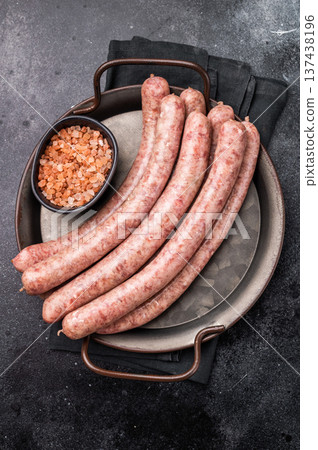 Close up of uncooked raw sausage showcasing its juicy texture, ideal for flavorful dishes and culinary creativity. black background. top view Close up of uncooked raw sausage showcasing its juicy texture, ideal for flavorful dishes and culinary creativity. black background. top view 137438196