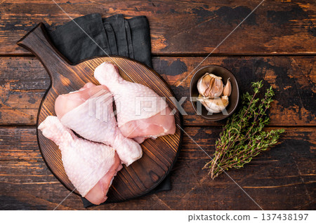 Uncooked poultry drumsticks, raw chicken legs ideal for your favorite recipes, waiting to be seasoned and cooked to perfection. wooden background. top view Uncooked poultry drumsticks, raw chicken legs ideal for your favorite recipes, waiting to be seasoned and cooked to perfection. wooden background. top view 137438197