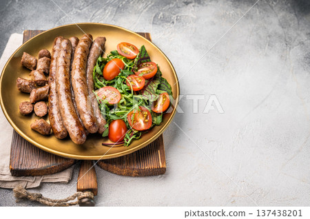 Close up of perfectly charred grilled sausage with salad, ideal for adding flavor to your favorite dishes or sandwiches. white background. top view 137438201