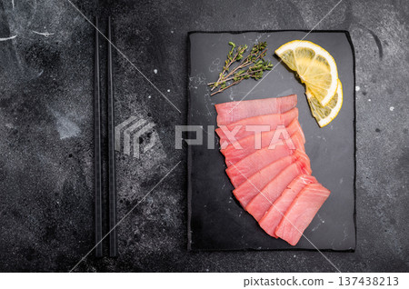 Premium quality tuna sashimi, ideal for a refreshing appetizer or light meal that delights the senses. black background. top view Premium quality tuna sashimi, ideal for a refreshing appetizer or light meal that delights the senses. black background. top view 137438213