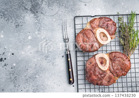 Tender veal osso buco, cross cut shank simmered in rich sauce, a timeless recipe that delights the senses and warms the heart. grey background. top view 137438230