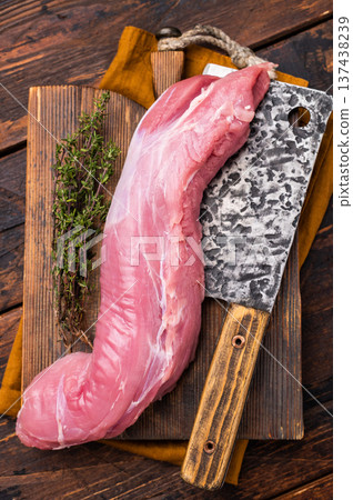 Juicy uncooked pork tenderloin, a versatile choice for any culinary creation you have in mind. wooden background. top view Juicy uncooked pork tenderloin, a versatile choice for any culinary creation you have in mind. wooden background. top view 137438239
