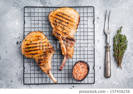 Juicy grilled pork Tomahawk chop, perfectly seared and bursting with flavor, ideal for a hearty feast. grey background. top view 137438256