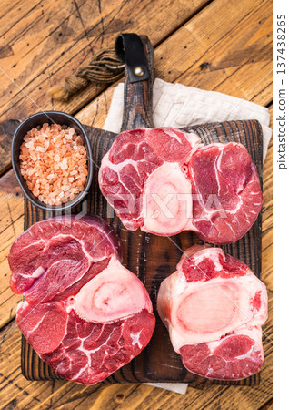 Fresh raw ossobuco, osso buco meat, showcasing tender veal shank with rich marrow, perfect for gourmet Italian dishes. wooden background. top view Fresh raw ossobuco, osso buco meat, showcasing tender veal shank with rich marrow, perfect for gourmet Italian dishes. wooden background. top view 137438265