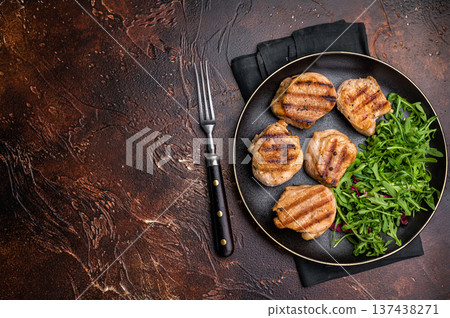 Savory charred pork loin medallion, tenderloin meat showcasing its tender texture and rich flavors after grilling. brown background. top view 137438271