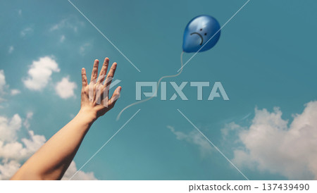 Mind, Mental Health. Hand releasing Blue Sadness Balloon to sky 137439490