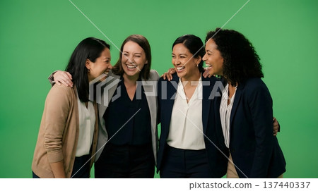 Four professional women of diverse ethnicities sharing a moment of joy and camaraderie in a studio. 137440337