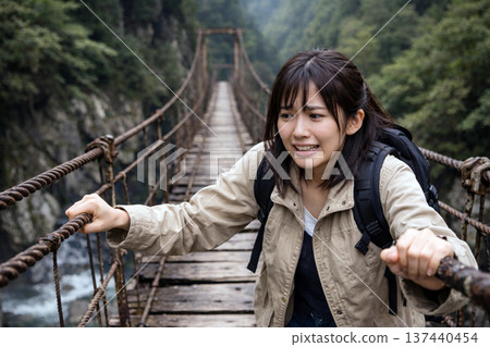 A woman crossing a suspended bridge 137440454