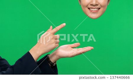 Surreal concept of a woman's smiling head floating above a hand gesturing against a green screen background. Surreal concept of a woman's smiling head floating above a hand gesturing against a green screen background. 137440666