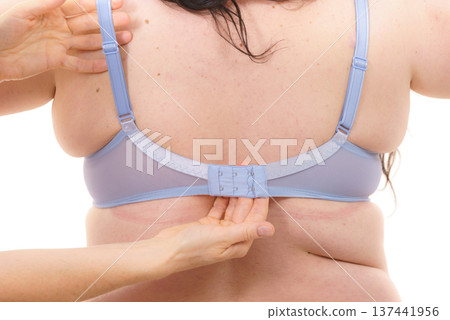 Bra fitter help plus size woman find perfect fit. Back view. 137441956