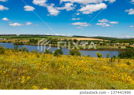 Summer landscape with beautiful lake, green meadows, hills, trees and blue sky Summer landscape with beautiful lake, green meadows, hills, trees and blue sky 137441990