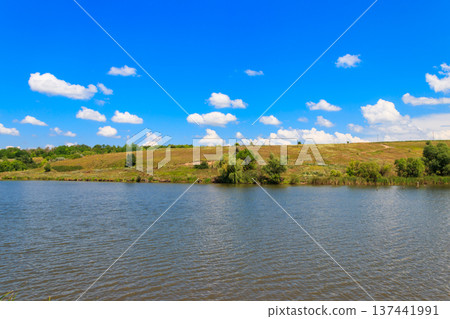 Summer landscape with beautiful lake, green meadows, hills, trees and blue sky Summer landscape with beautiful lake, green meadows, hills, trees and blue sky 137441991